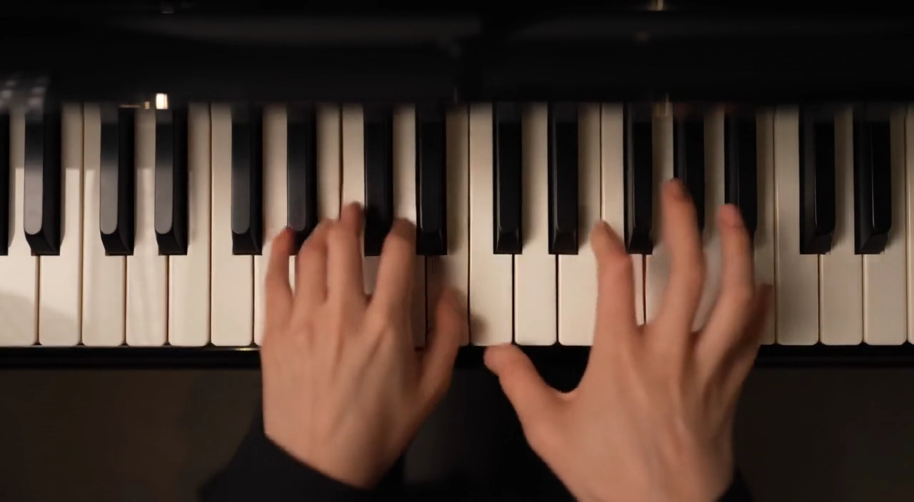 A frame from Black Forest Labs' own FLUX 3 audio demo showing two hands playing a piano, illustrating the native audio FLUX 3 generates with the video